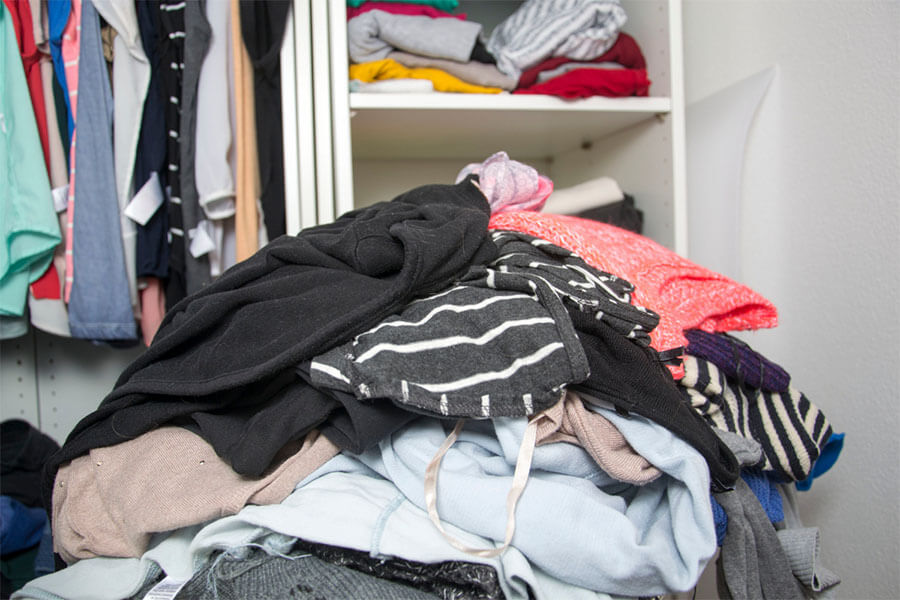 Ropa amontonada en una habitación para botar a la basura porque está pasada de moda